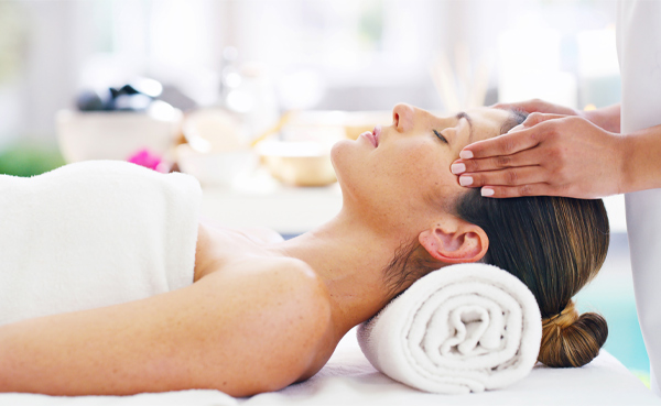 female therapist doing tickle massage on female head