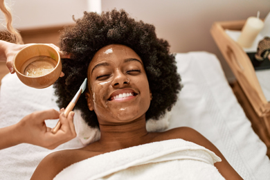 smiling woman getting facial from spa