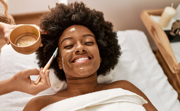 smiling woman receiving facial at spa