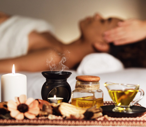 indian head massage in spa room with essential oils and candles