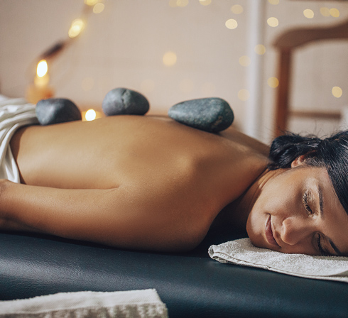 relaxed woman having hot stone massage at spa